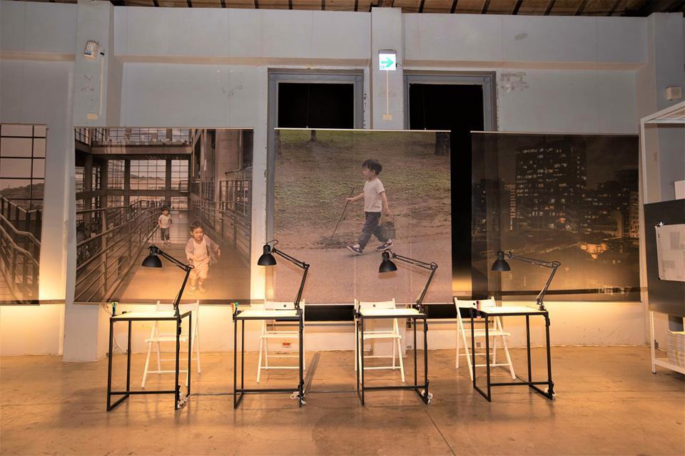 「美角｜生活中的每一課」展場紀錄照片，書桌排列在展場海報前
