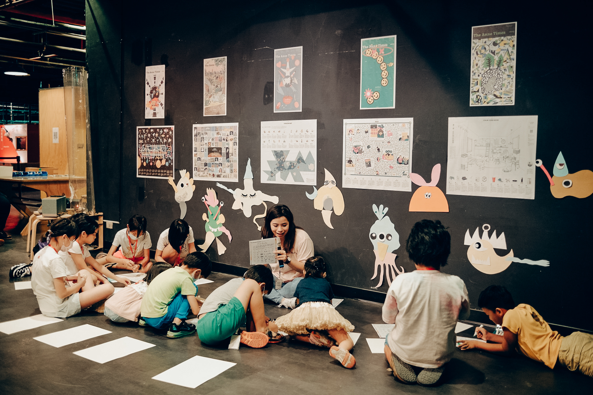 安妮新聞於科教館實施工作營，孩童圍在老師前面寫學習單