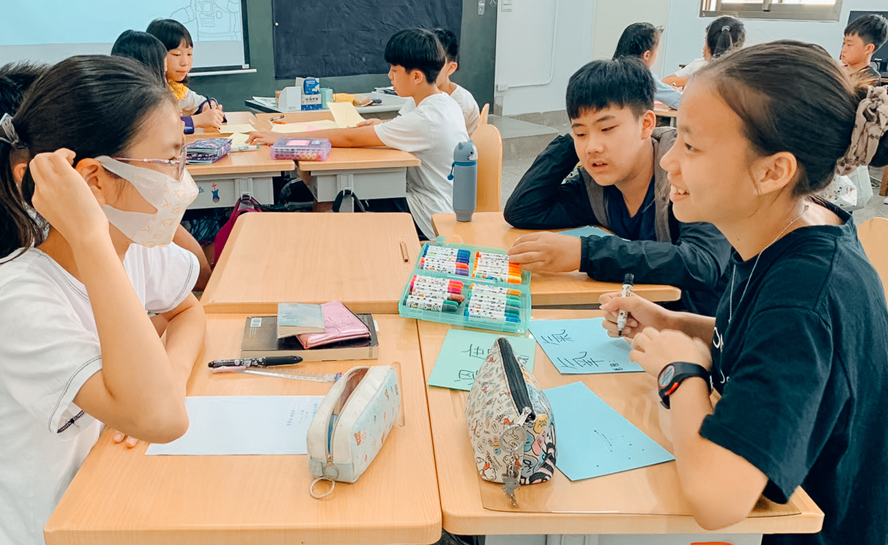 三名學生併桌討論字卡內容要寫什麼